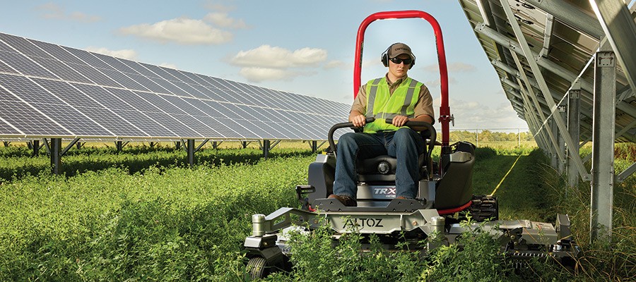 Altoz tracked lawn mower with a deck wing extension practicing precision for solar farm operations and maintenance.