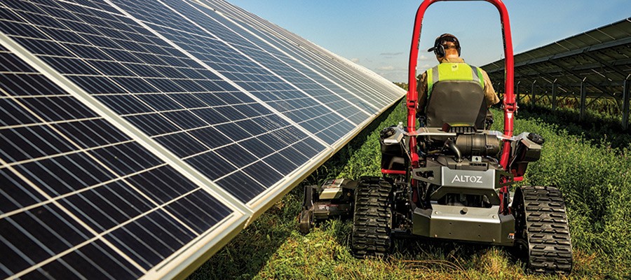 Altoz tracked commercial solar mower performing solar farm ground maintenance around panels.